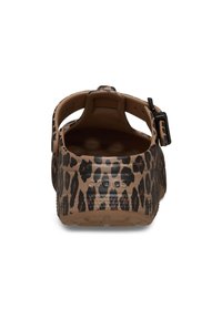 Zuecos con estampado de leopardo en tono marrón con manchas negras, que cuentan con una correa trasera y una suela texturizada. Material suave y diseño redondeado.