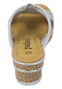 Zilveren faux leather sandaal met een kurk-textuur zool, ronde neus, gele binnenzool en decoratieve stiksels. Twee verstelbare banden zichtbaar.