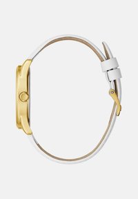 Zijaanzicht van een polshorloge met een gouden kast, witte leren band en gouden gesp, tegen een effen lichte achtergrond.