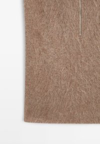 Maglione marrone lavorato a maglia con tessuto fluffy e texturizzato, dotato di una zip argentata al colletto.