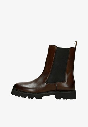 Brązowy skórzany botek za kostkę z elastycznymi panelami po bokach, zaokrąglonym noskiem i teksturowaną czarną gumową podeszwą. Wyposażony w pętelkę ułatwiającą zakładanie.