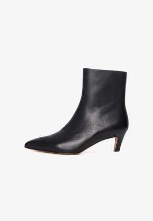 Stivaletto in pelle nera con punta affilata e tacco basso e affusolato. Texture liscia con dettagli minimi, che offre una silhouette elegante.