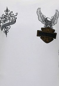 Witte T-shirt met zwarte grafische prints, waaronder "Local Fanatic Motorcycles" en een adelaar embleem met de tekst "Honor Local Loyalty".