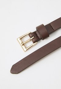 Brun læderbælte med en guld metalspænde, der har en glat overflade og traditionelt design. Stropen indsnævres mod enden.