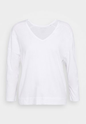 Biała bluzka z długim rękawem, dekoltem w kształcie V, szerokimi rękawami i miękką teksturą. Prosty design bez wzorów i detali metalowych.