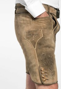 Shorts en cuir marron avec broderies décoratives. Comprend une poche latérale et des accents en boutons le long de la couture inférieure. Fini lisse et texturé.