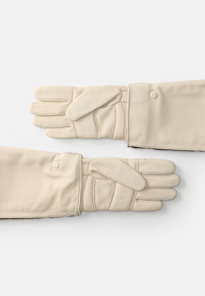 Kreminės odinės pirštinės su siuvinėtu raštu, turinčios lankstymo dizainą ir spaudžių užsegimus. Sklandus paviršius ir matomi pirštų angos.