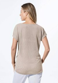 Beige, T-shirt met korte mouwen en een ronde hals, in een relaxte pasvorm, gemaakt van lichtgewicht stof. De achterkant is iets langer en heeft een gladde textuur.