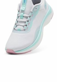 Sneaker bianco con una tomaia in tessuto testurizzato, dettagli azzurri, tallone rosa e suola curva e ammortizzata per il comfort.