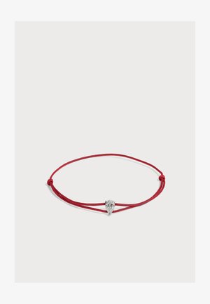 Bracelet en cordon rouge avec des nœuds réglables, présentant une pierre précieuse claire en forme de poire dans un sertissage argenté au centre.