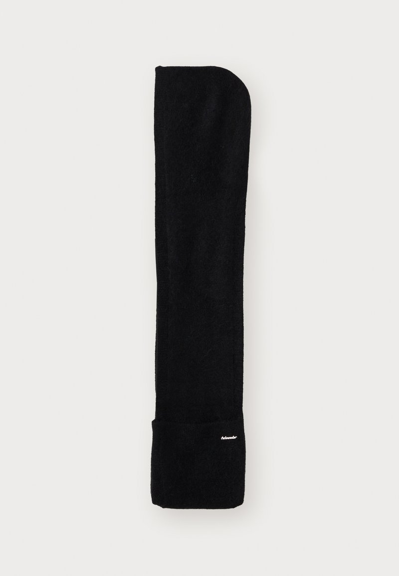 Mustasirune, pikk sall pehmest kangast. Omab ümarat tippu ja väikest logo alumises osas. Lihtne, minimalistlik disain.
