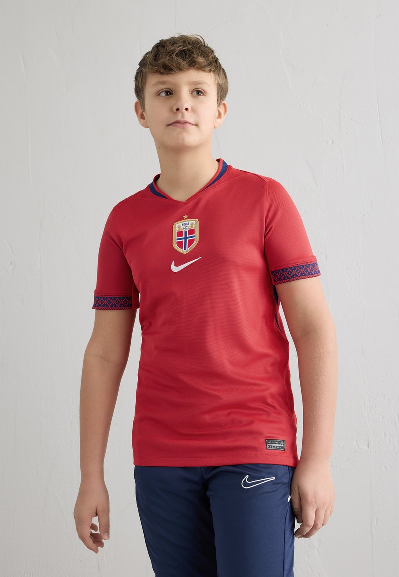 Punane lühikeste varrukatega jalgpallimärk, ümara kaelusega ja siniste detailidega; kiri ja Nike logo, valmistatud kergetest materjalidest.