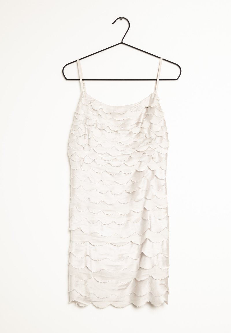 Bezrukávové šaty z lehkého šedého saténu s vrstevnatým vlnitým vzorem. Mají rovný výstřih a tenké ramínka. Visí na černém háčku.