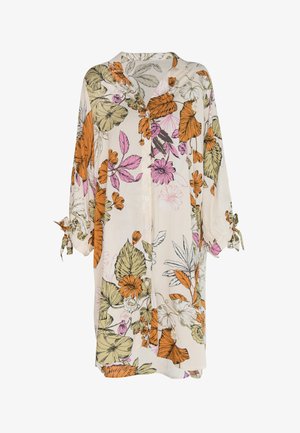 Camisa de botones floral en crema, con estampados botánicos en naranja, rosa y verde, mangas largas con lazos y un corte relajado.