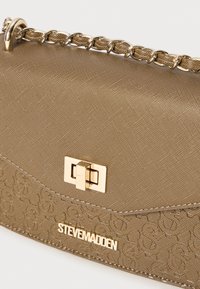 Gullfarget veske med strukturert tekstur, slank form, preget mønster og en gullfarget lås. Har en kjede stropp for bruk som crossbody eller på skulderen.