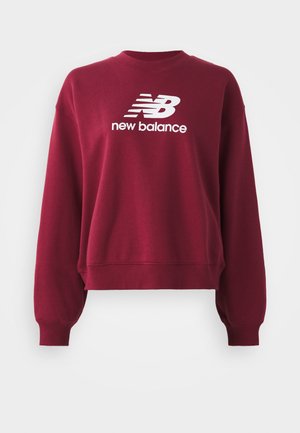 Sweatshirt bordeaux avec un col rond côtelé, des épaules tombantes et des manches longues. Présente un logo blanc "New Balance" sur le devant.