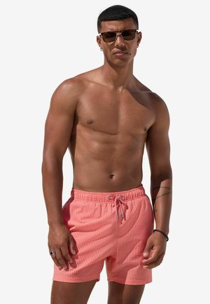 Rosa gestreifte Badeshorts mit elastischem Bund und Kordelzug. Glatte Textur, lässige Passform und seitliche Taschen vorhanden.