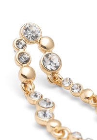 Pulsera de cadena en tono dorado que presenta cristales claros en forma circular y de corte redondo. Textura suave con disposiciones alternas de cuentas y piedras.