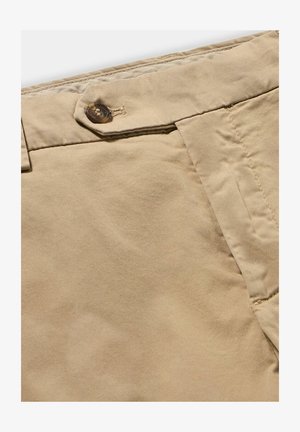 Beżowe bawełniane spodnie z zapięciem na guzik, płaskim przodem i gładką teksturą, z widocznymi szwami i lekko pomarszczonym wyglądem.