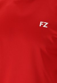 Röd sporttröja med en slät textur och rund halsringning, med en vit "FZ"-logotyp på framsidan.