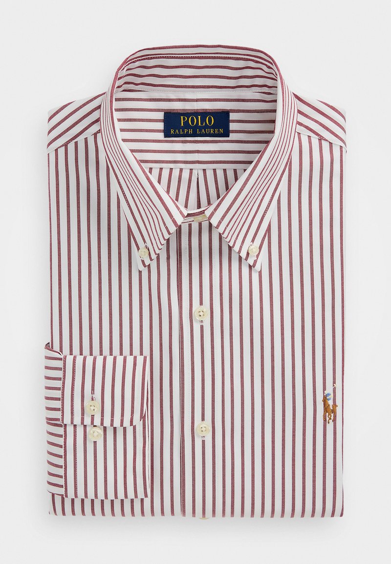 Taiteltu valkoinen kauluspaita, jossa pystysuuntaiset punaiset raidat, nappikiinnitteinen kaulus ja Polo Ralph Lauren kirjailtu logo rinnassa.