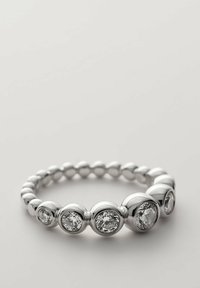 Anello in argento con accenti alternativi sferici e a faccette simili a diamanti, che presenta una superficie liscia e lucida.