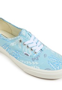 Ljusblå canvas sneakers med vita snörningar, med ett blommönster i mörkare blå nyanser. Gummisula, märkt med Vans-logotyp.