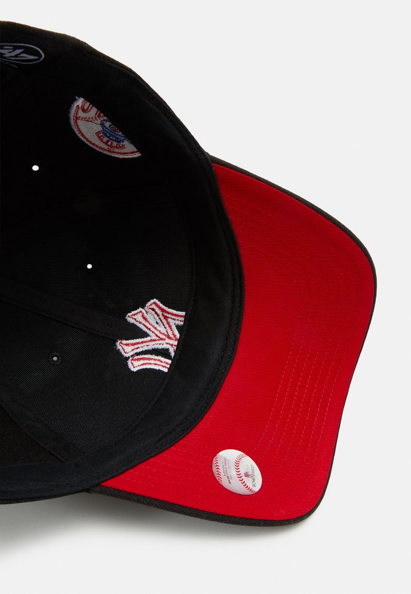 Gorra de béisbol negra y roja con visera plana, que presenta un logotipo blanco bordado en rojo, patrones en el interior y una etiqueta con forma de pelota de béisbol.