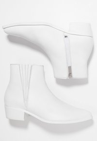 Botas blancas de tobillo con un diseño elegante, que cuentan con un cierre lateral, costuras texturizadas y un tacón bajo en bloque. Material de cuero suave.