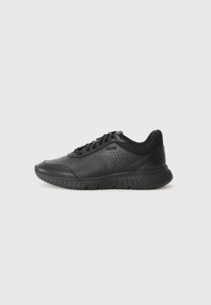 Sneaker nero basso con tomaia in pelle strutturata e mesh, chiusura con lacci frontale e suola in gomma spessa su sfondo neutro.