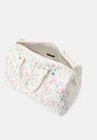 Blomster dusjete bagasje i krem med rosa og blå blomster mønstre, gull glidelåser og doble håndtak; romslig interiør vist.