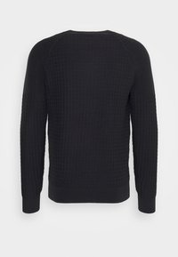 Pullover nero a maniche lunghe con un motivo a griglia testurizzato e polsini a costine, mostrato da dietro su uno sfondo neutro.