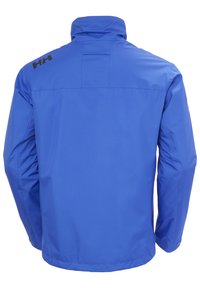 Blauwe waterdichte jas met een hoge kraag, elastische manchetten en reflecterend logo-detail op de schouder. Glad synthetische stofafwerking.