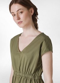 Vestido verde oliva con escote en V, mangas cortas y cinturilla elástica, hecho de una tela ligera con una textura suave.