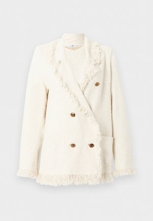 Κρεμ σακάκι διπλής όψης με υφή κρέμας, με φούντες στο γιακά, τα μανίκια και το τελείωμα, που διαθέτει τέσσερα καφέ κουμπιά και δύο μπροστινές τσέπες.