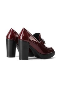 Scarpe con tacco in pelle verniciata bordeaux, con punta arrotondata, decorazioni sul collo del piede e una zeppa nera spessa.