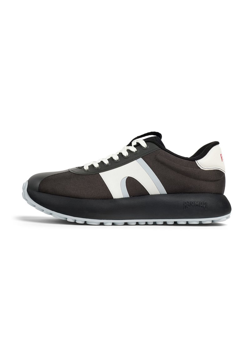 Scarpa sportiva bianca e nera con una parte superiore in rete testurizzata, punta rotonda, suola spessa in gomma e un logo prominente sul tallone.