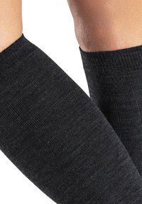 Schwarze gestrickte Armschoner haben eine glatte Textur und ein enganliegendes Design, mit einem gerippten Bündchen an der Oberseite für Komfort und Stabilität.