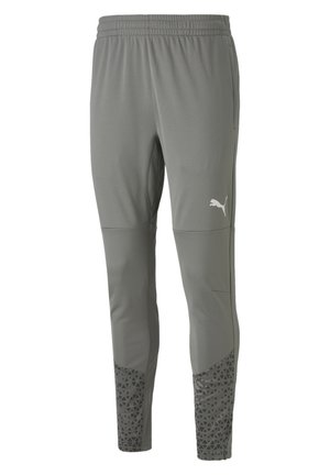 Grijze sportbroek van een gestructureerde stof, met een elastische tailleband en een gemêleerd ondergedeelte met driehoekige patronen. Witte logo zichtbaar.