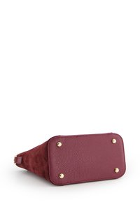 Bordeaux leren handtas met suede en textuuraccenten. Heeft afgeronde hoeken en gouden hardware nagels aan de basis voor stabiliteit.