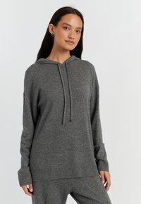 Sweat-shirt à capuche gris en maille douce, doté d'une coupe décontractée, de poignets et d'un ourlet côtelés. Comprend une poche frontale.