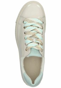 Bílé lakované kožené tenisky s texturovanými světle modrými akcenty, které mají tkané šňůrky v modré, béžové a zlaté barvě a kulatou špičku.