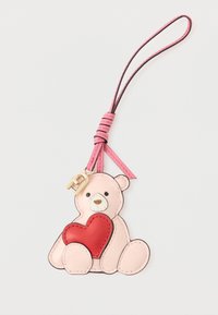 Un breloc cu un ursuleț din piele roz care ține o inimă roșie, cu o curea roz și accesorii din aur, cusături detaliate și trăsături faciale.