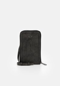 Svart dragkedjeplånbok i texturerat material. Har en minimalistisk design, smal form och ett band med en metallspänne.