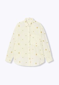 Chemise blanche à boutons avec broderie florale jaune, manches longues, poche poitrine et ourlet arrondi. Fabriquée en tissu léger.