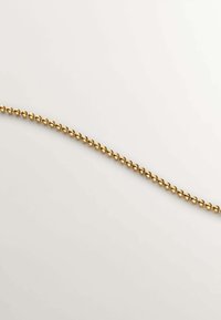 Cadena de cuentas en tono dorado con cuentas esféricas reflectantes, espaciadas de manera uniforme a lo largo de un hilo flexible, sobre un fondo claro.