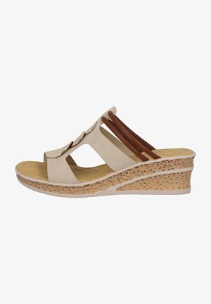 Sandalia de cuña beige con punta abierta, que presenta tres correas decorativas y una suela texturizada estilo corcho. Los acentos incluyen detalles metálicos sutiles.