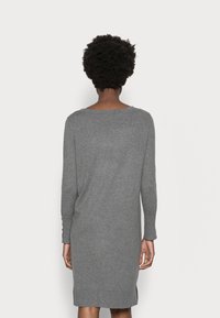 Robe pull grise à manches longues en laine douce, avec un col rond et de légentes fentes sur les côtés à l'ourlet.