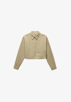 Gekürzte, langärmlige Bluse aus leicht olivgrünem Stoff. Verfügt über einen spitzen Kragen, eine Knopfverschluss und eine einzelne Brusttasche. Weiche Textur.