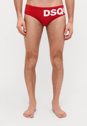 Rote Bikini-Brief aus glattem Stoff mit einem wiederholenden Logo-Muster und auffälligem weißen "DSQUARED2"-Text am Bund.